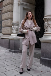a lady in a pink wrap coat and a pair of knit pants